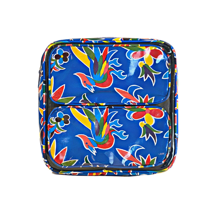 Front view: Two small travel cases, multi-colored flower/animal print on blue background, fitting inside large case.