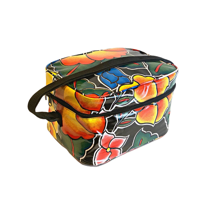 Angle view: Large multi-colored floral print lunch box with black strap handle. 